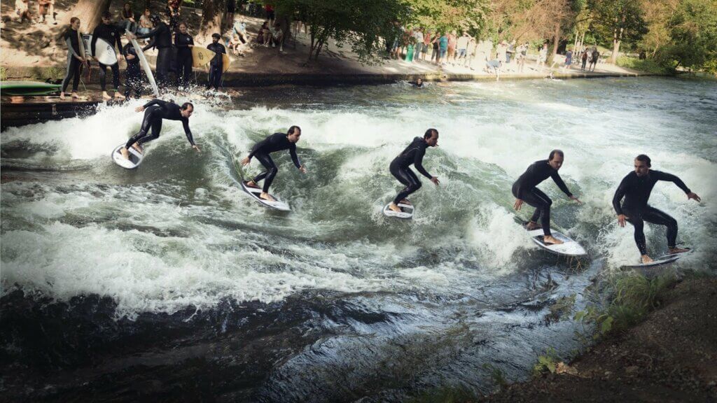 A group of people riding surfboards on top of a river