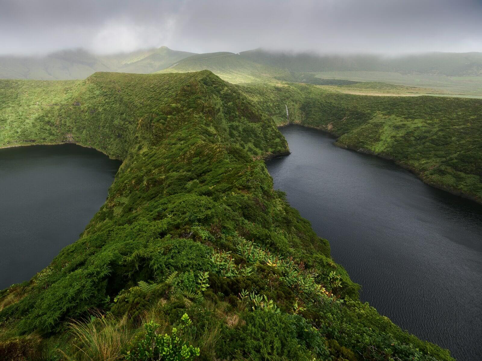 Ferienpass gams: Tiere 1 Lush green hills surround dark blue lakes under cloudy sky