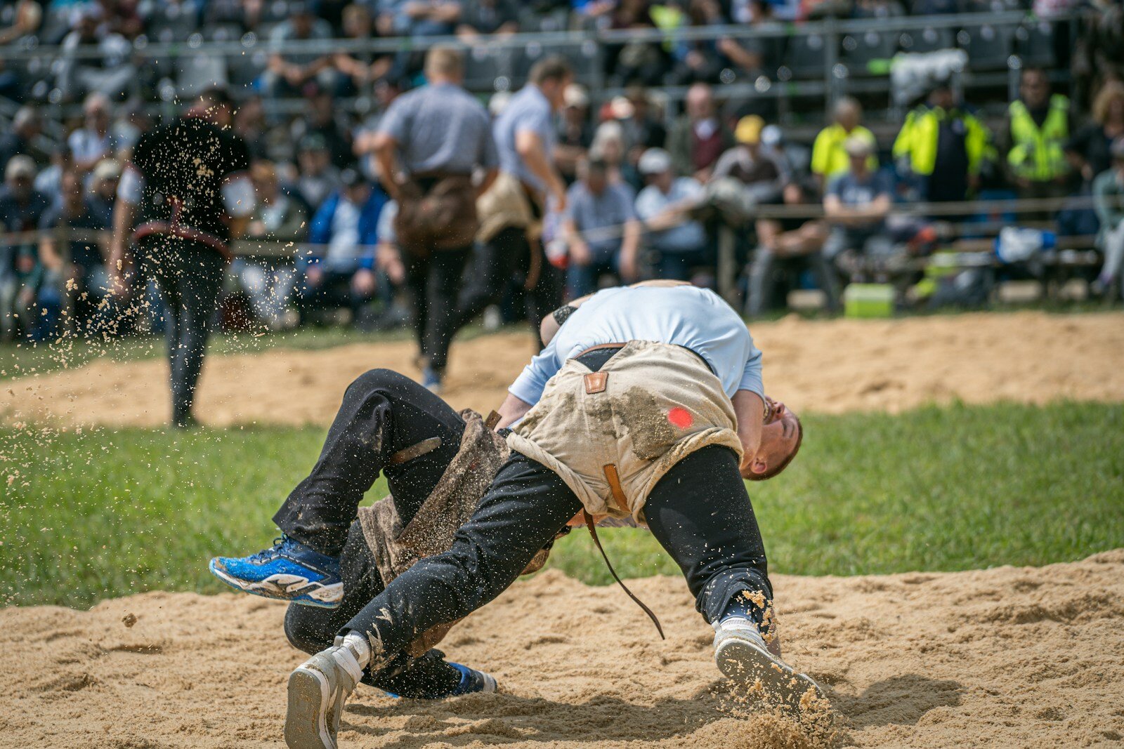 Wrestlers are competing in an outdoor competition.