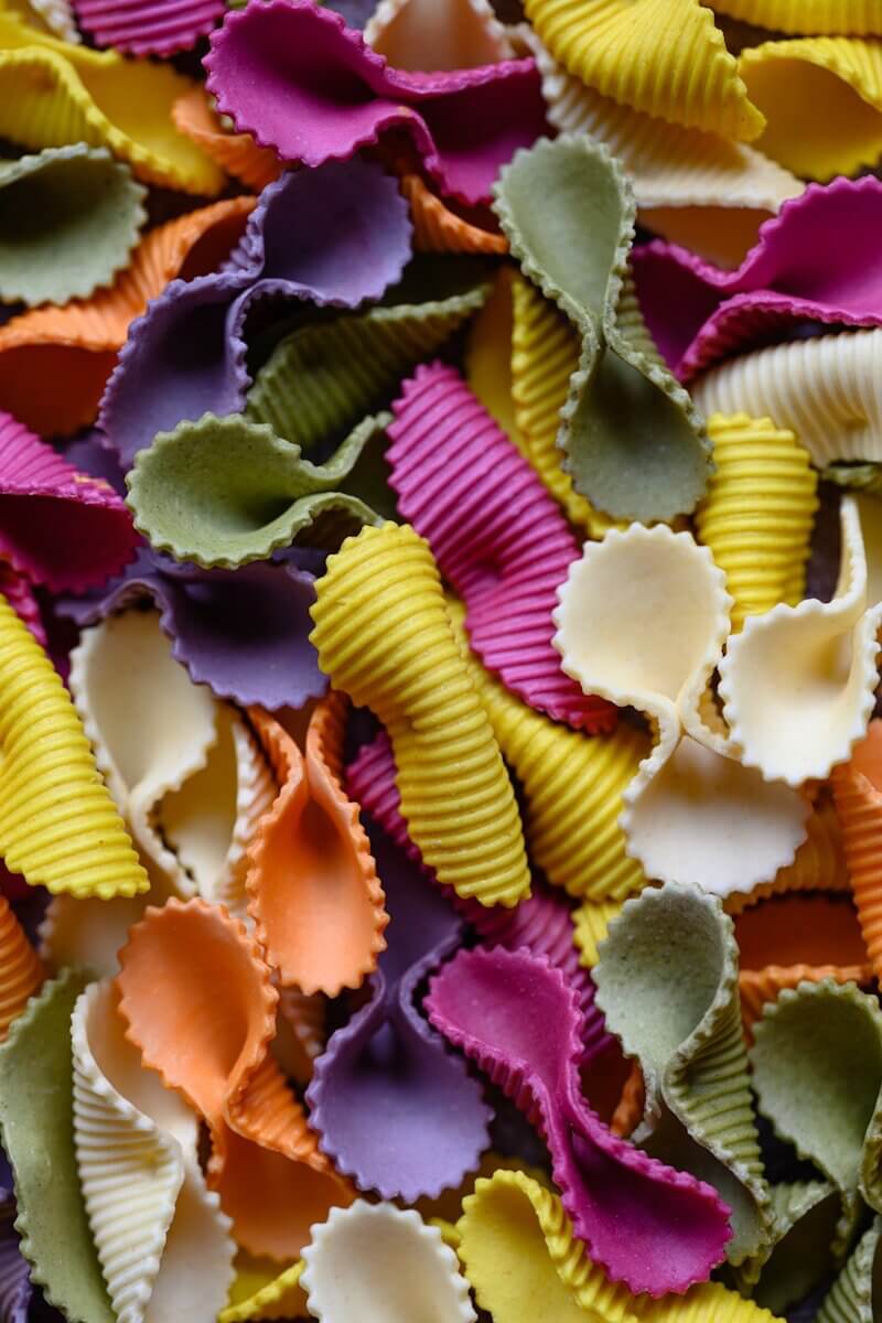 a pile of colorful pasta shells sitting on top of a table