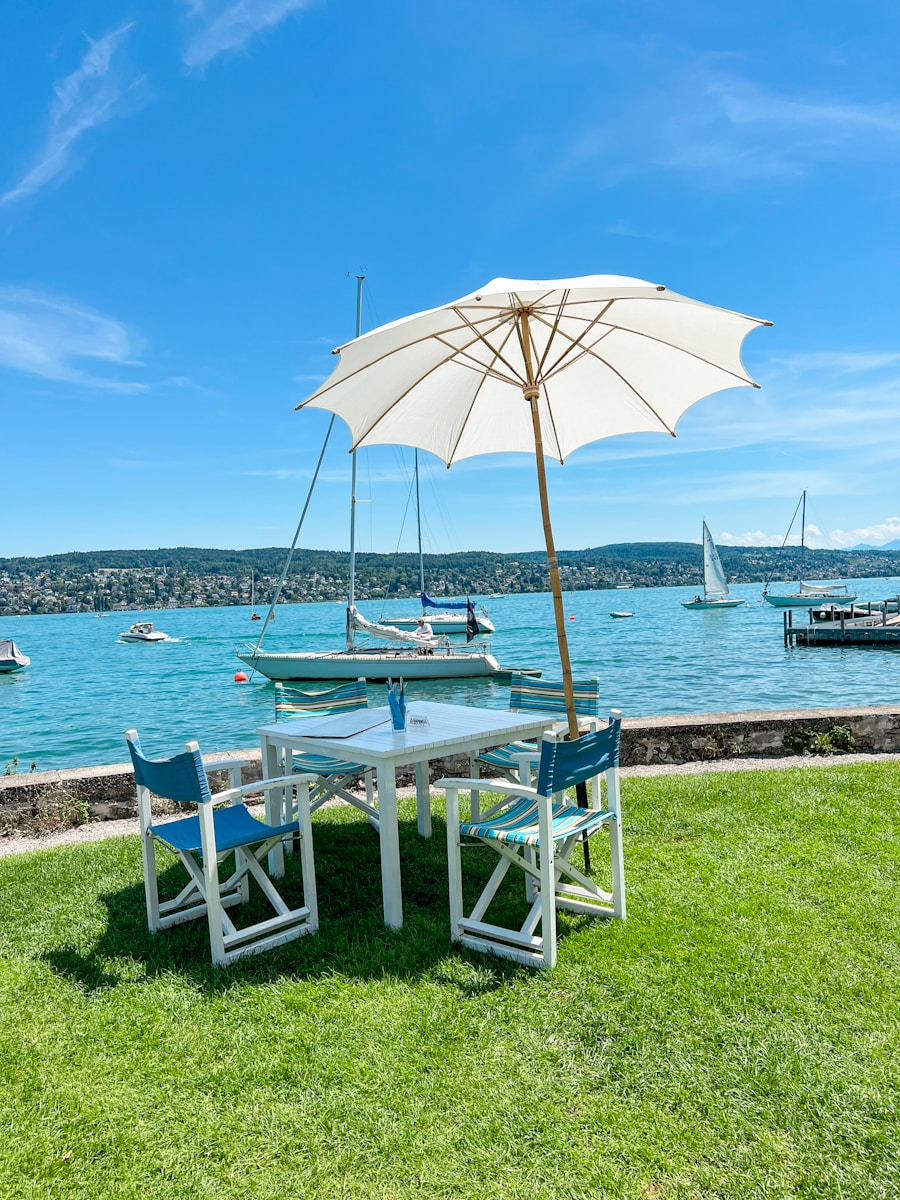 a table and chairs next to a body of water