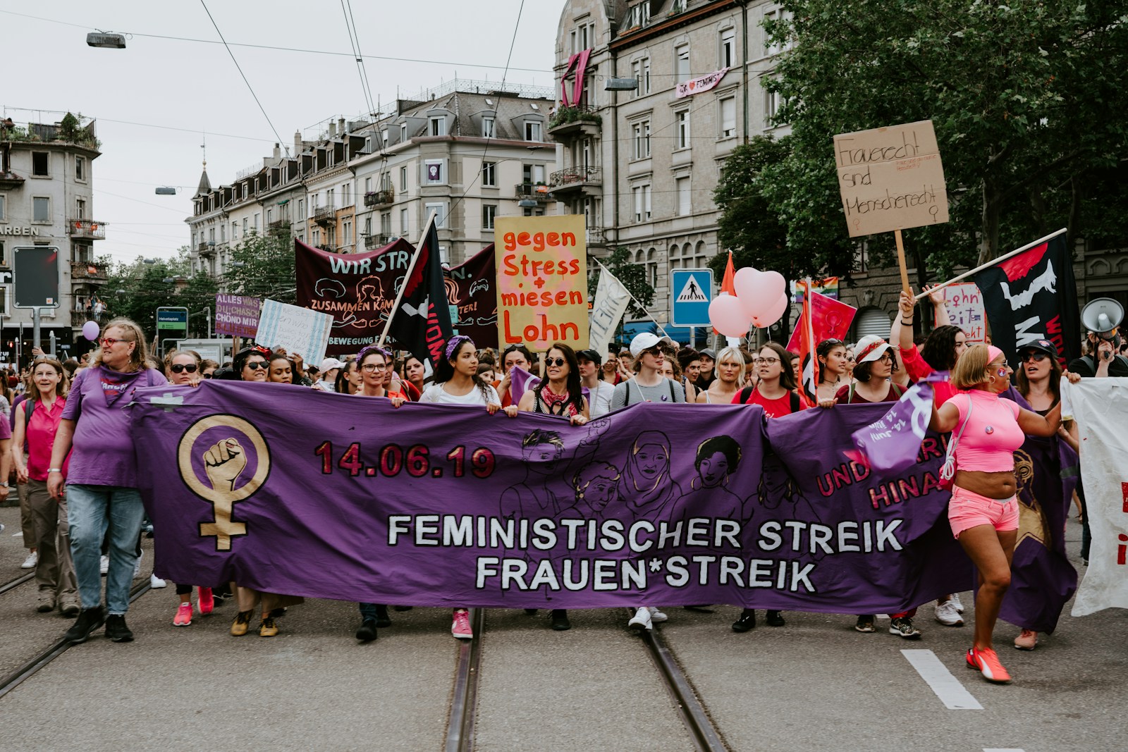 Schule Oberrieden: Frauenrechte 1 group of people holding purple banner