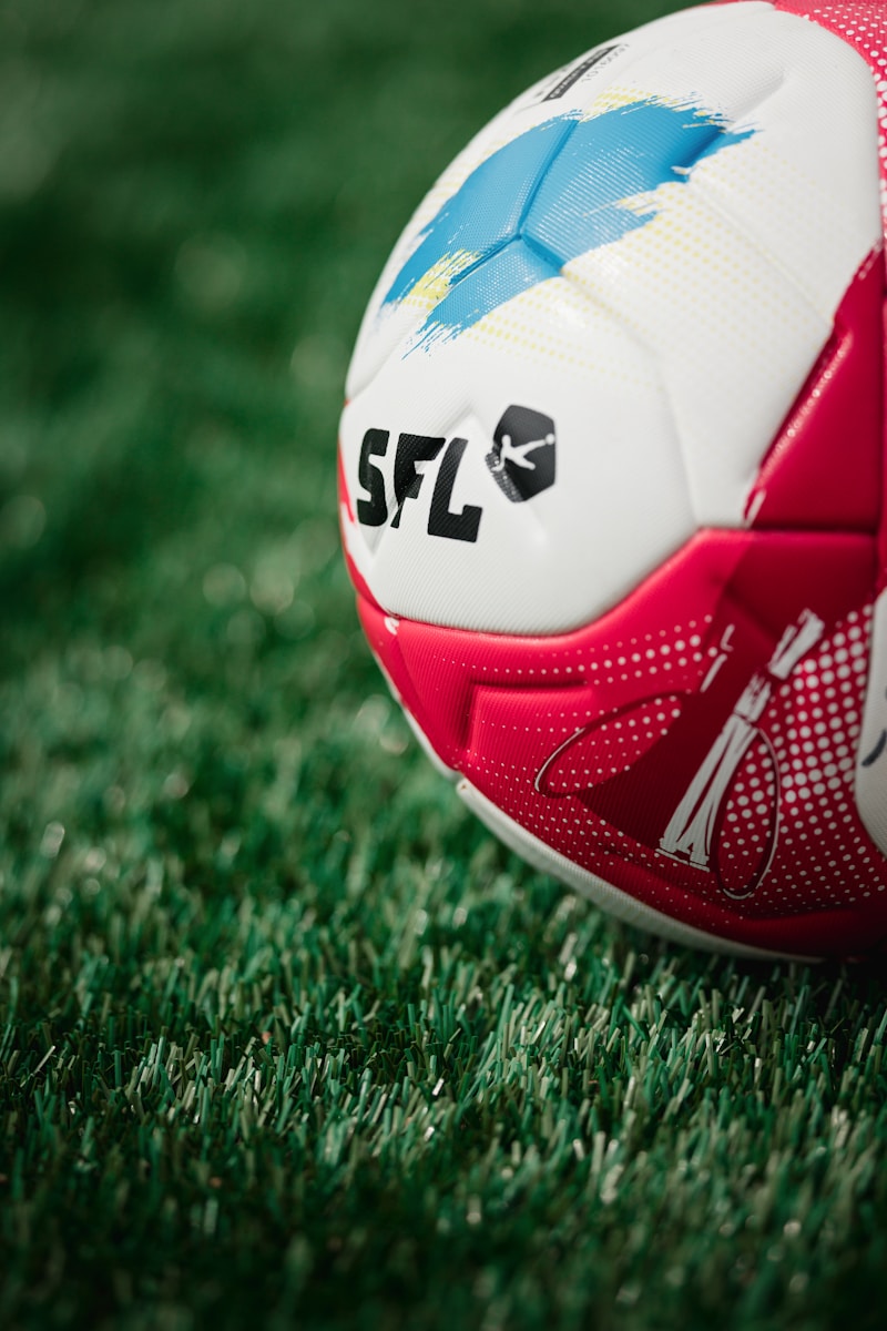 A soccer ball rests on a green grassy field.