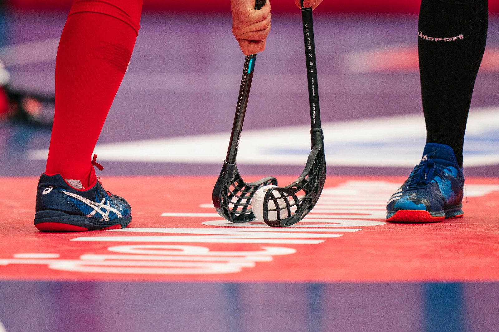 Ferienpass Herzogenbuchsee: Unihockey 1 person in red pants wearing black and white nike sneakers