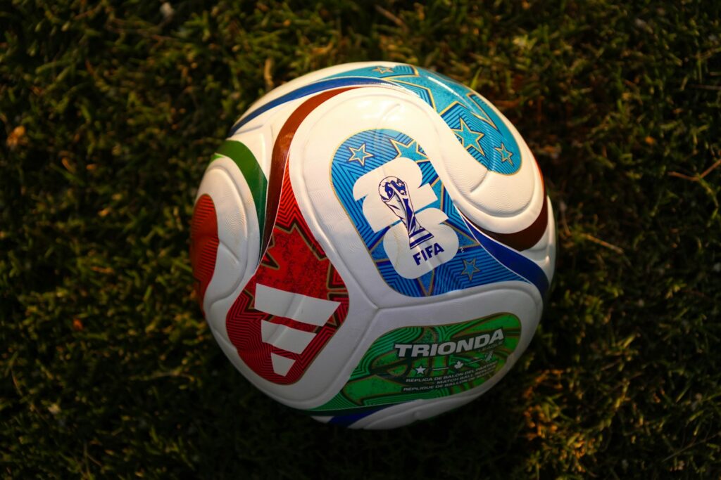 A colorful soccer ball rests on green grass.