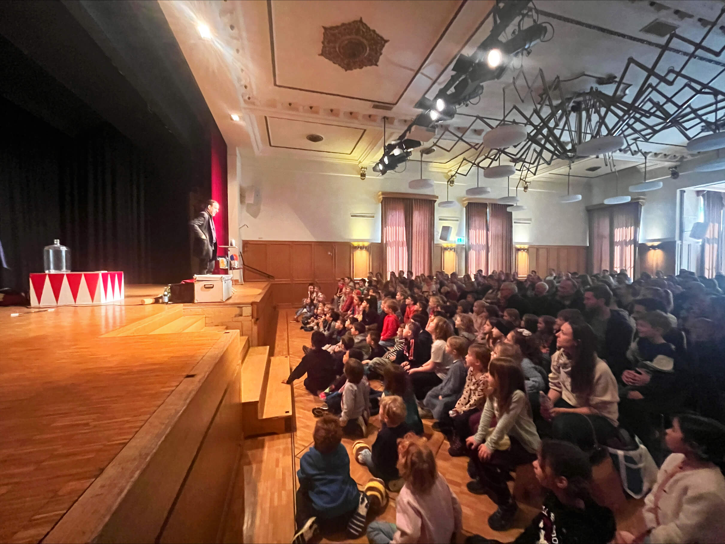 Dan White verzaubert Rüti | Vor ausverkauftem Publikum fand am vergangenen Samstag um 14:00 Uhr eine magische Vorstellung in Rüti statt, als Dan White seine Zaubershow präsentierte. Vor 130 begeisterten Kindern und 99 Erwachsenen entfaltete der Kinderzauberer eine fesselnde Mischung aus Zauberei, Comedy und Bauchreden, die das Publikum in Staunen versetzte. processed D4DB5192 9DBC 46A8 BEEB 192F31CFC37C |