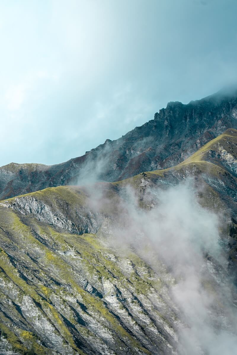a view of a mountain with a lot of clouds coming out of it