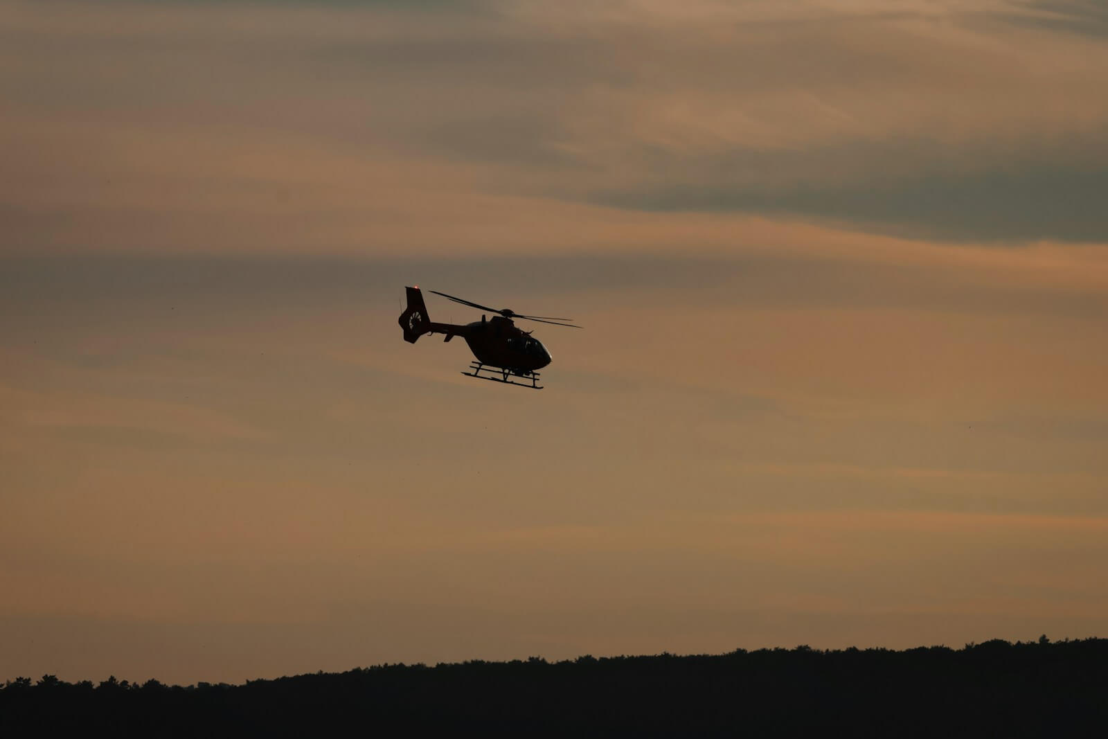 Ferienpass Zell: Hellikopterabsturtz | A helicopter flying in the sky at sunset