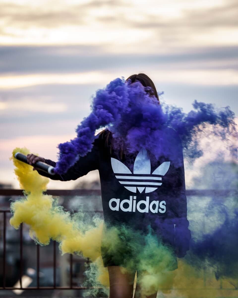 man in black jacket holding yellow smoke